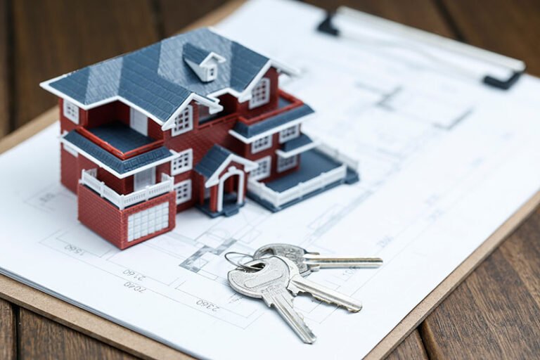 Maqueta de una casa sobre un plano dibujado en papel y unas llaves nuevas